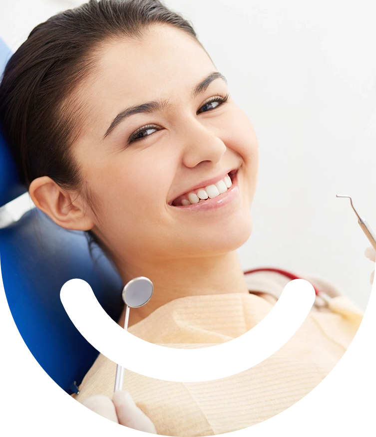 A woman smiling while sitting in the dentist chair.