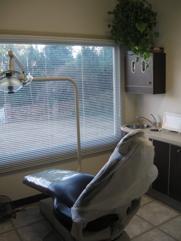 A dentist 's chair in front of the window.