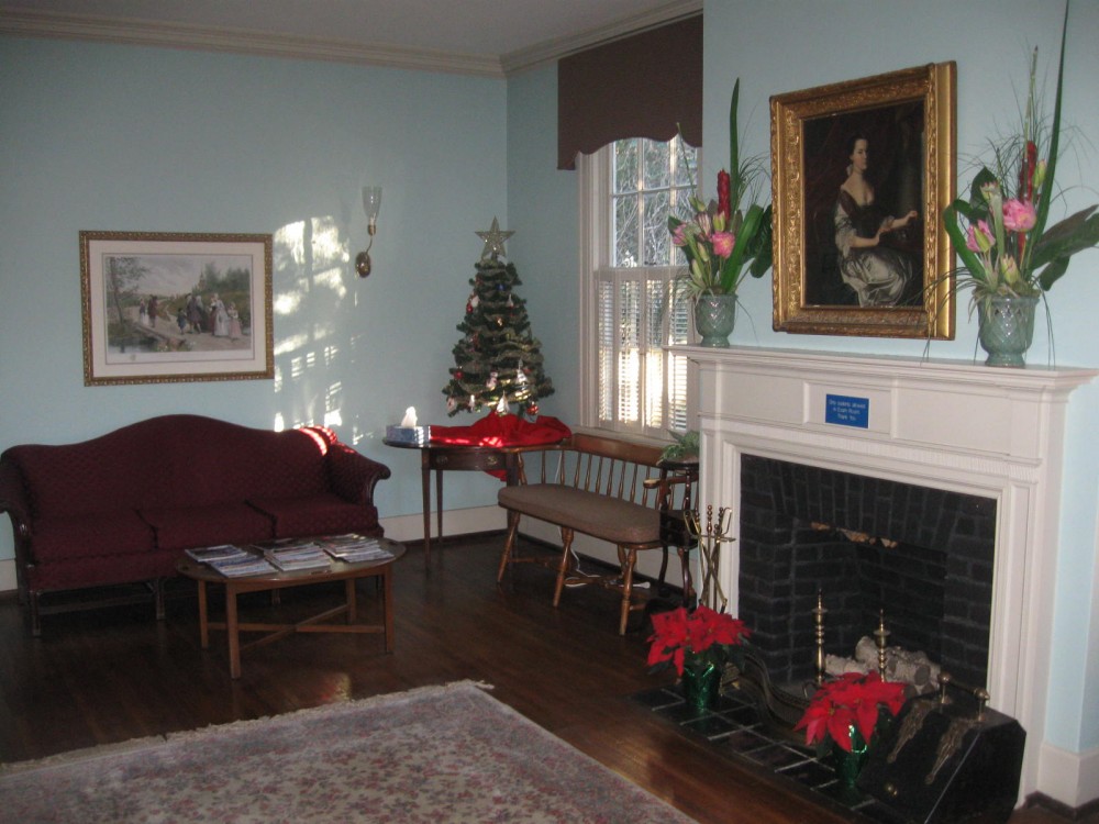 A living room with a fireplace and christmas decorations.