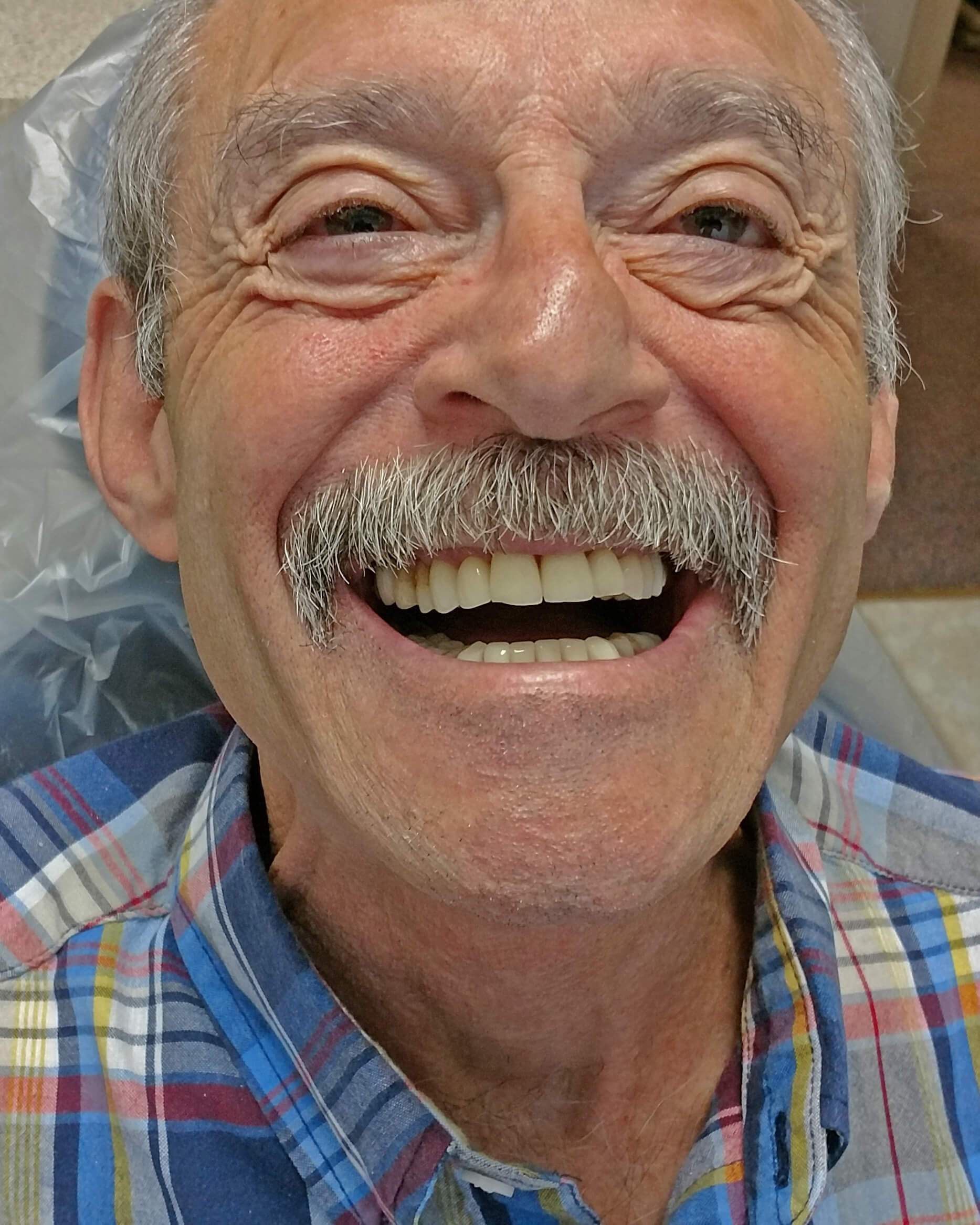 An Elderly Person Smiling Wide At The Camera