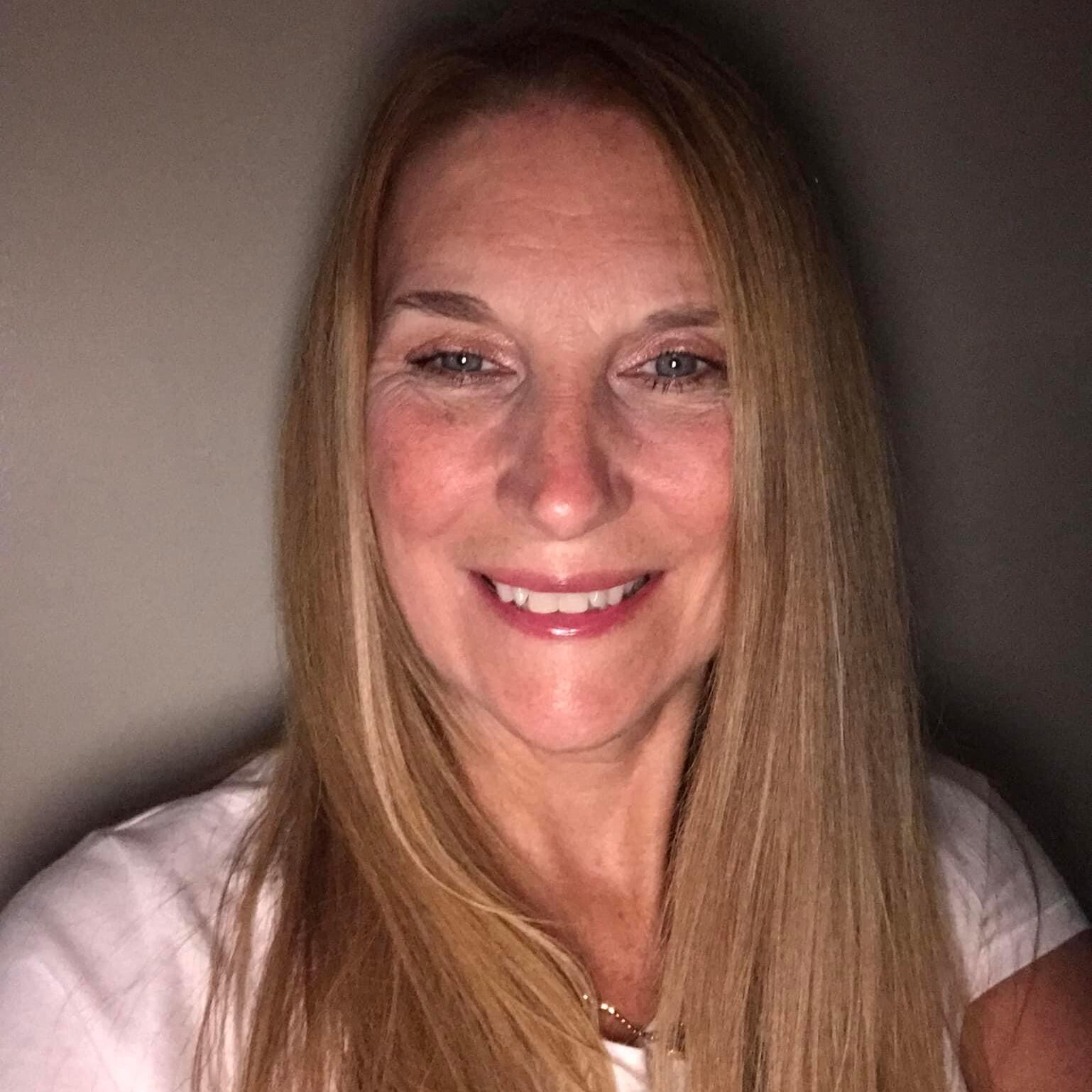 A woman with long hair smiles for the camera.